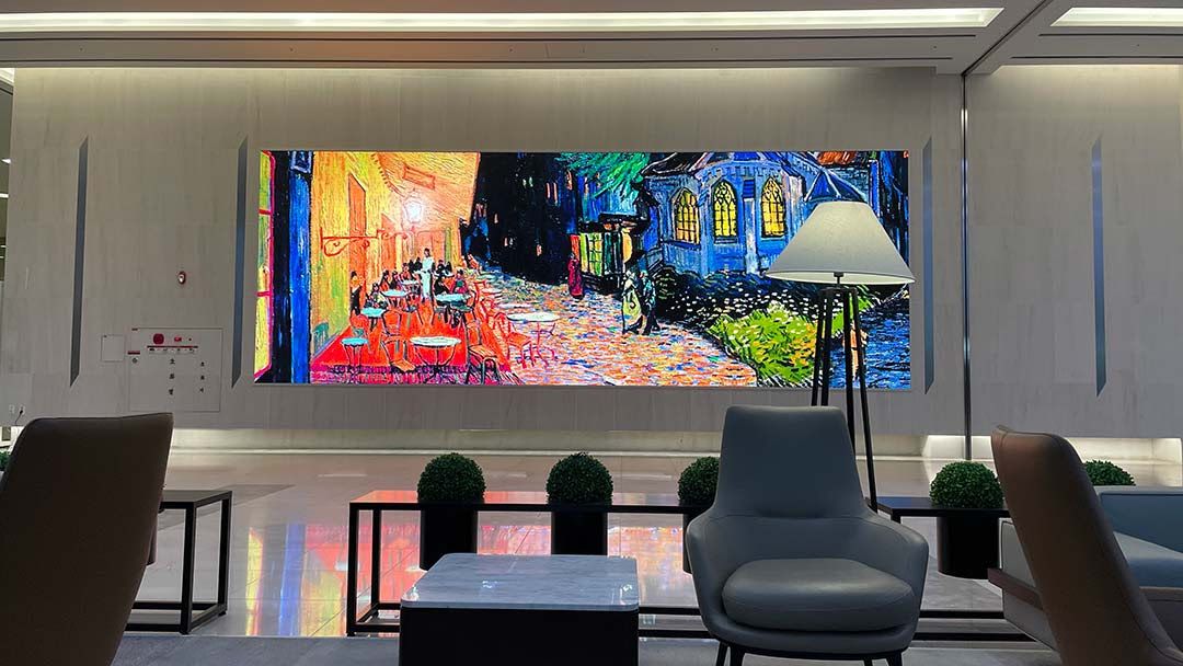 A bright Daktronics display presents a digital art mural in a lobby.