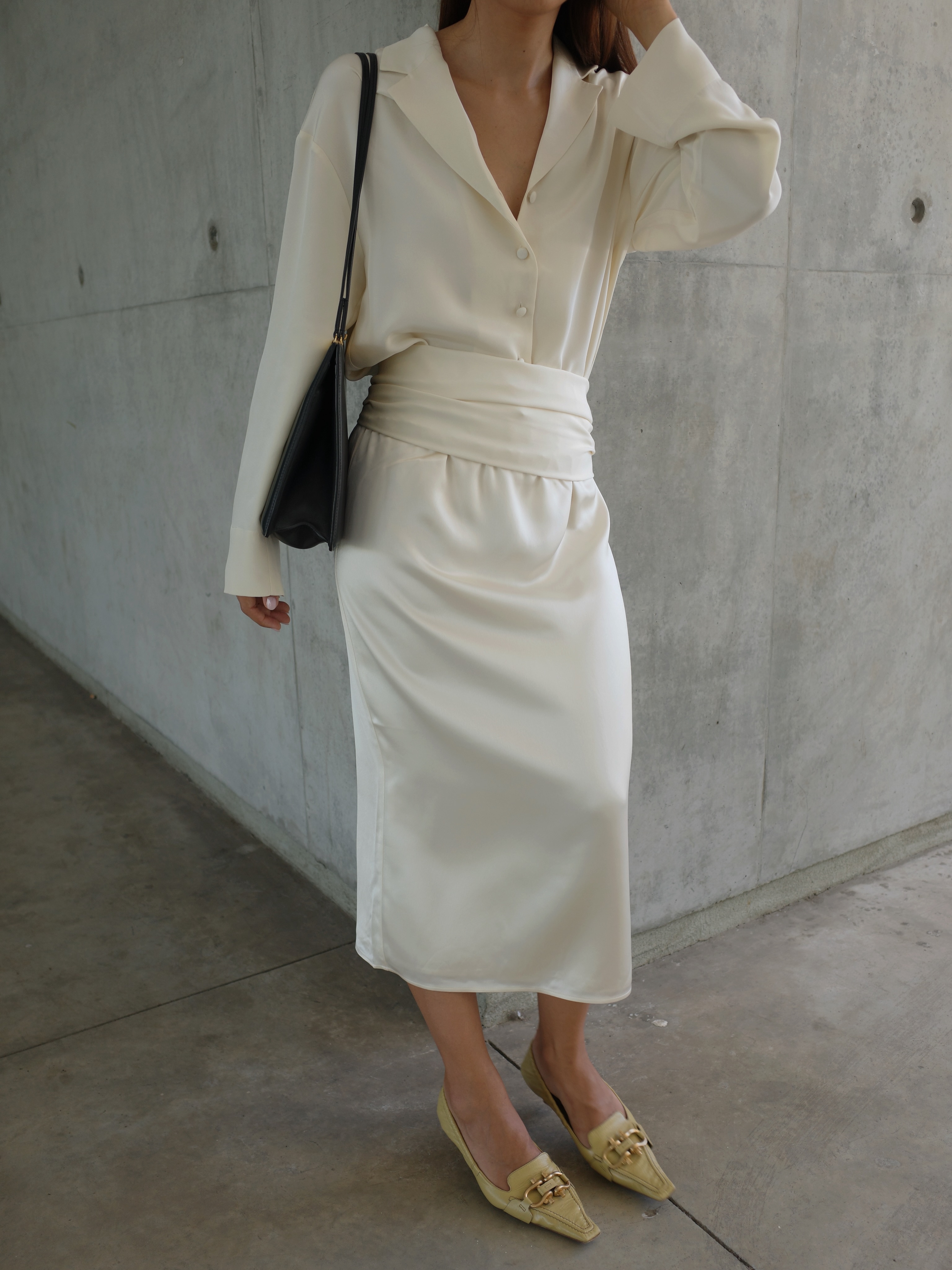 An image of @deborabrosa wearing a white silk shirt and silk skirt from sustainable fashion brand Almada.