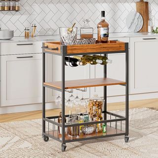 A multifunctional kitchen trolley featuring a black metal frame with wooden shelves and a top tray. It includes wine bottle storage, hanging racks for glasses, and lower shelves for additional barware or snacks.