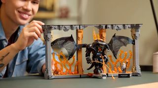A man places a piece on the open Lego Balrog Book Nook