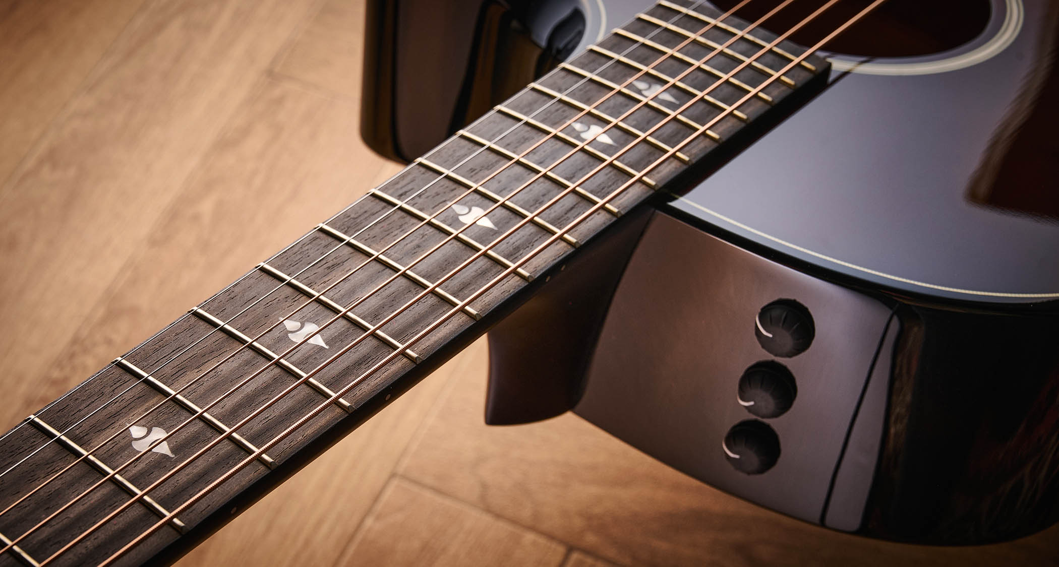 Taylor Builder’s Edition 514ce Kona Burst pictured against a wooden floor and patterned rug.