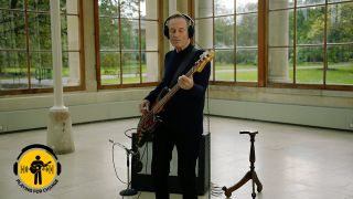 John Paul Jones playing bass in an empty room