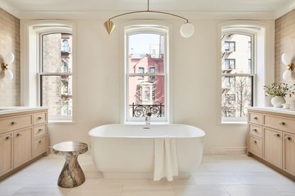 A bathroom with a thin, minimalistic pendant/chandelier