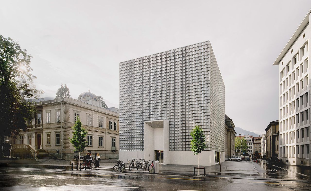 A photo of the street home to the Buendner Kunstmuseum in Chur, Switzerland. This is a cube style building with its main colour being white. 