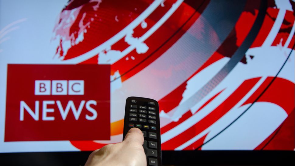 Man watching BBC News on TV