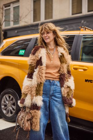 A street style image of a chic woman wearing an on-trend outfit on the streets of New York City during fashion week.