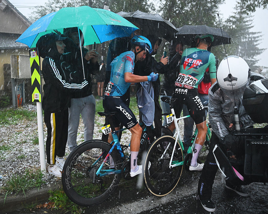 Lorenzo Fortunato and Mats Wenzel take cover under the umbrellas of some spectators