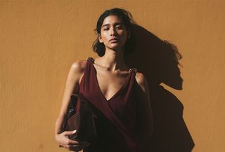 a model wearing an H&M burgundy dress