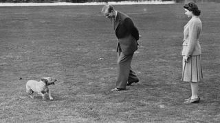 Princess Elizabeth and the Duke of Edinburgh playing with the Princess's pet corgi Susan