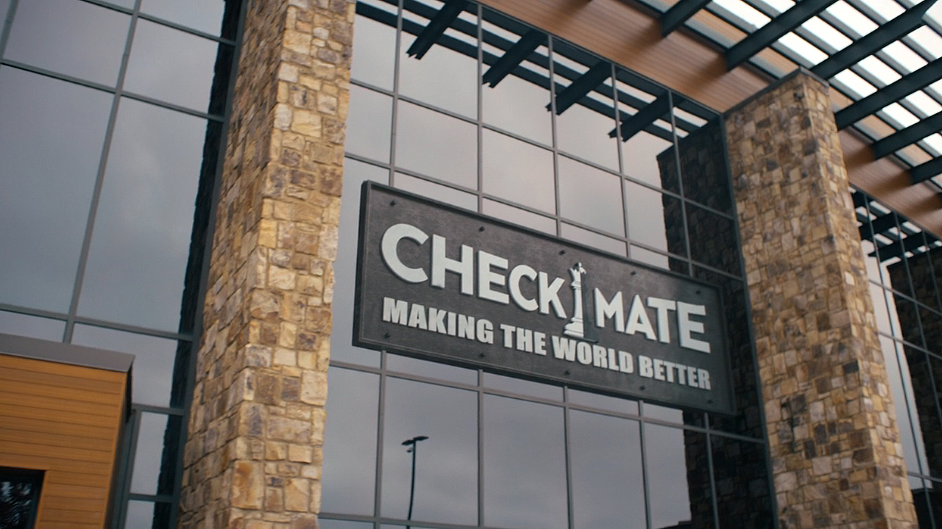 A screenshot of the Checkmate agency logo on a building front in Peacemaker season 2 episode 8