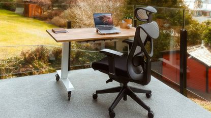 Lifestyle image of an office chair sat behind a desk overlooking a garden