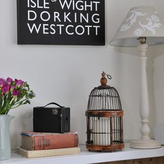 hallway table with birdcage and lamp