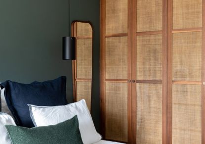 A bedroom with a built in wicker style wardrobe 