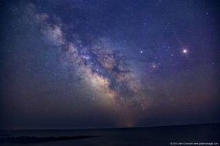 Mars and Saturn shine above the center of the Milky Way Galaxy in this spectacular night sky photo overlooking the Nantucket Sound in Massachusetts.