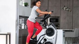 Bowflex Max Trainer M6 review: A woman in a grey sports t-shirt and red capri leggings exercises on the cross-trainer