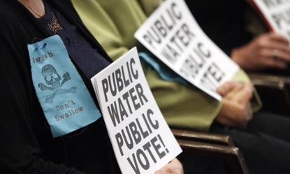 Protestors hold signs in Portland's City Hall during a 2012 vote to add fluoride to the city water.