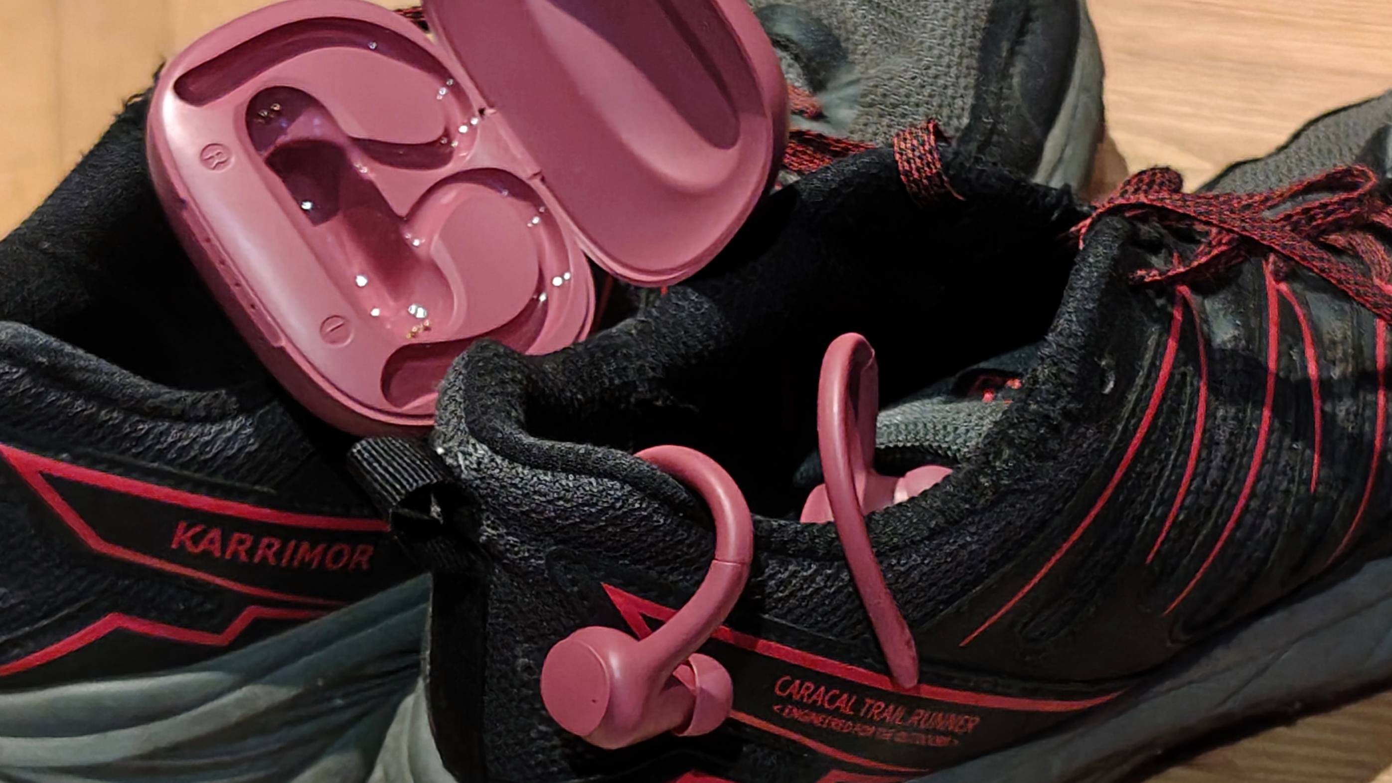 The Balco Sports Earbuds case and buds on some shoes.