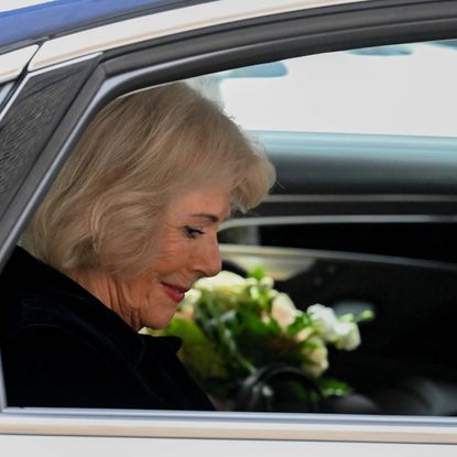 Queen Camilla riding in a car wearing black