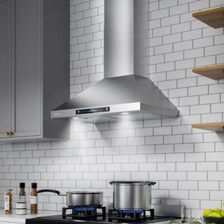 A silver range hood above a pot of boiling water