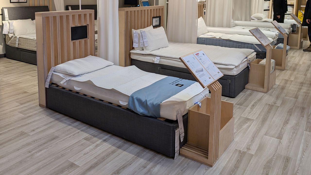 A mattress showroom with a wooden floor and multiple mattress on bed frames