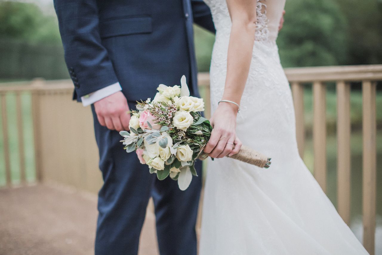 bride and groom at a wedding holding a bouquet