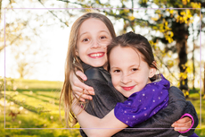two sisters smiling and hugging