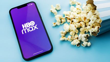 HBO Max logo on phone next to popcorn