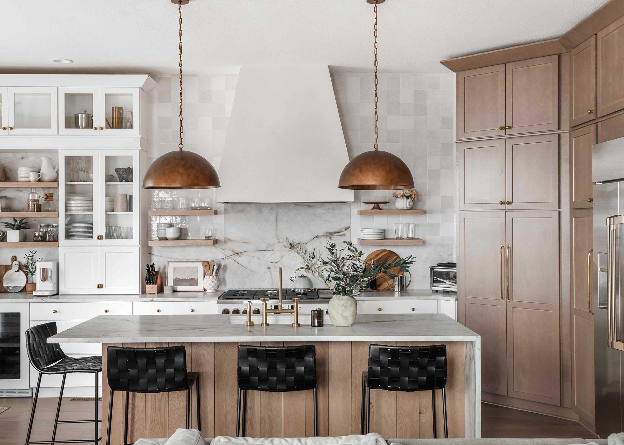 luxury wooden kitchen with brushed brass pendant lights over central island with sink