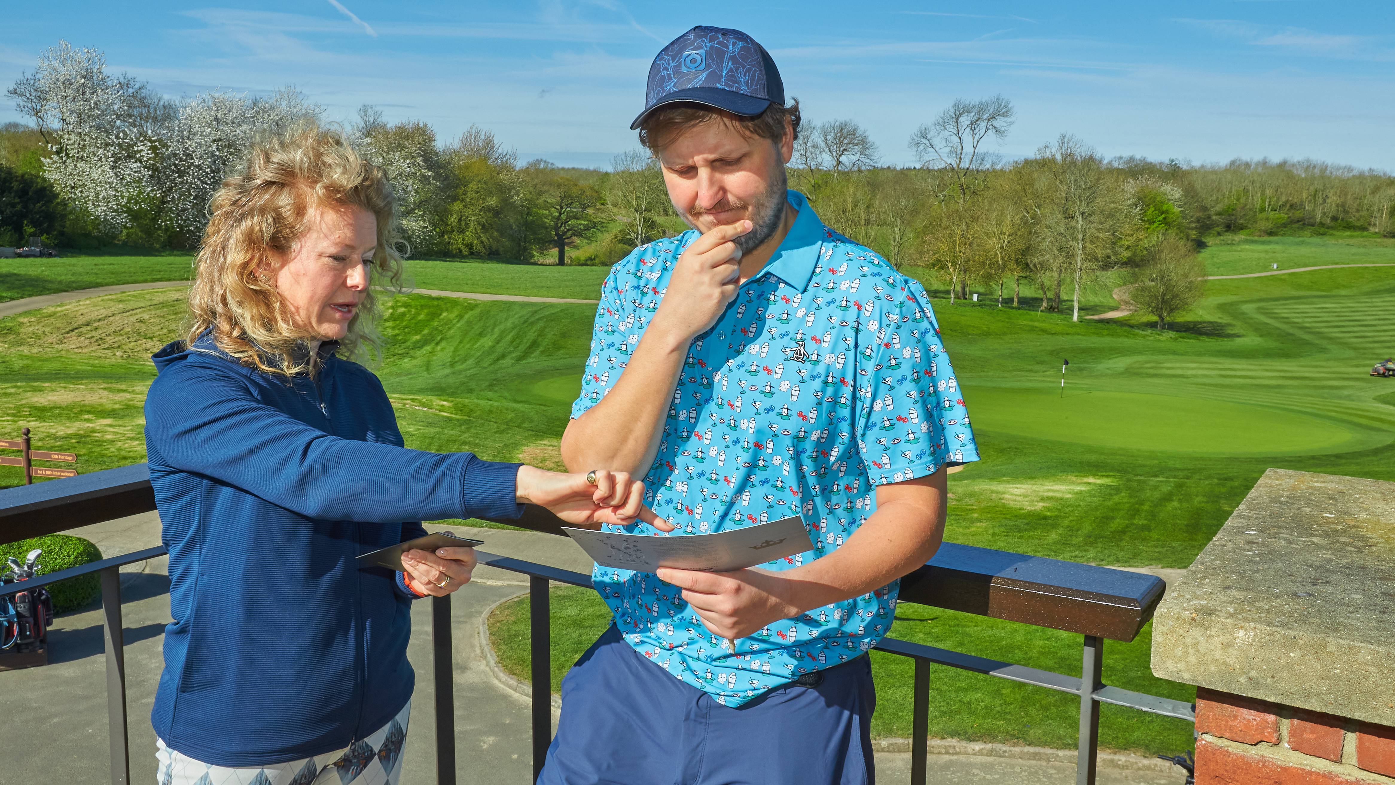 Two golfers looking pensively at a scorecard