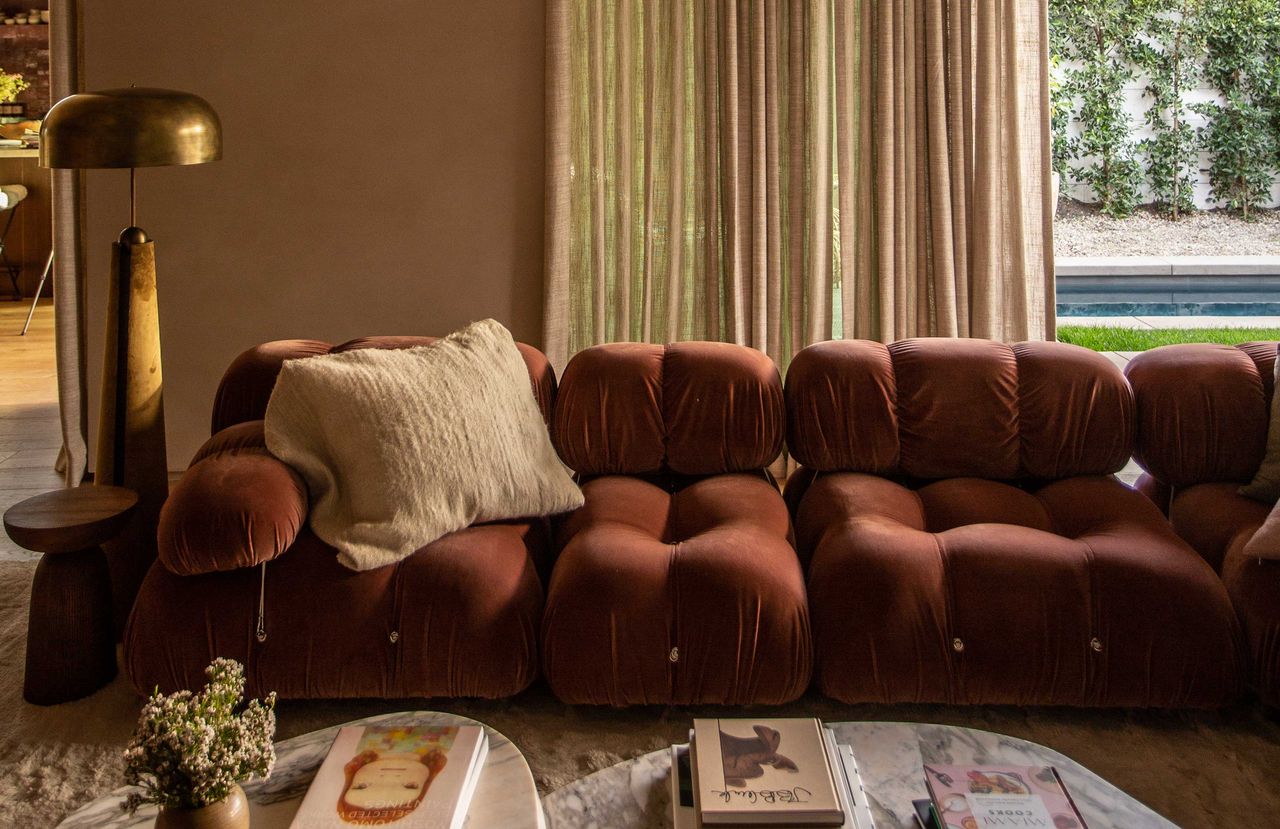 a beige living room with a red sofa