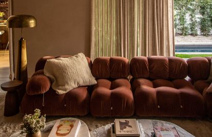 a beige living room with a red sofa