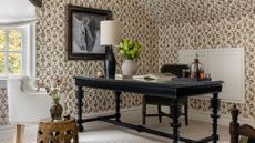 Equestrian-inspired home office area featuring botanical wallpaper, rustic furniture, and framed horse photography wall art