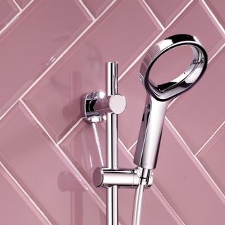 Pink tiled bathroom wall with chrome showerhead