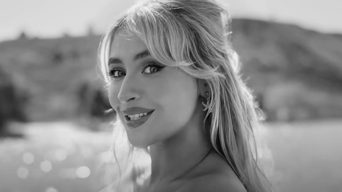 A black and white close up of Sabrina Carpenter smiling in the Espresso music video.