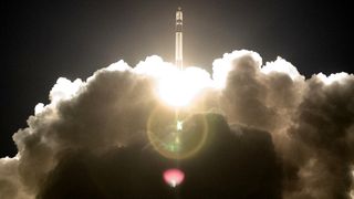 Rocket lifting off and surrounded by plumes of exhaust