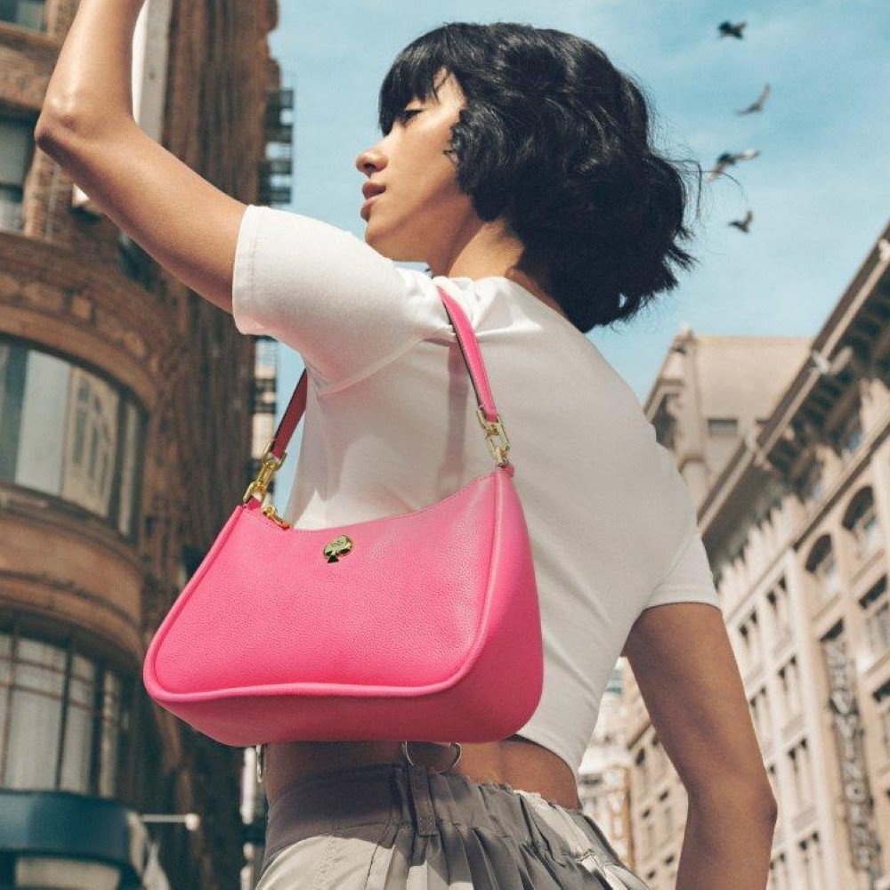 Model wearing a hot pink Kate Spade handbag