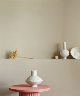 Neutral walls with pink side table and white ceramics