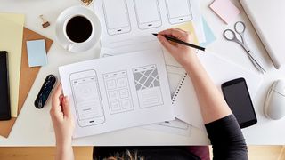 best wireframe tools: image of a woman at a desk sketching a wireframe 