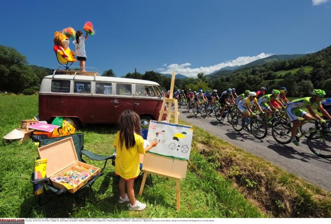 A young fan takes inspiration from the fast moving peloton
