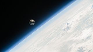 A white Boeing Starliner spacecraft floats above a blue Earth against the black of space on June 6, 2024.