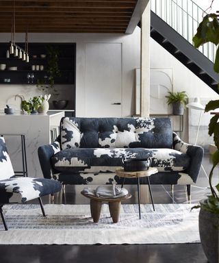 A cow-print sofa with accompanying armchair in living room