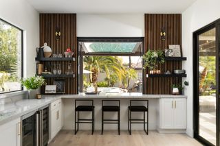 an indoor bar with a slatted wall and serving hatch