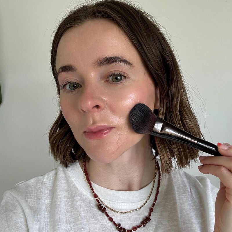 Grace luciendo la varita luminosa Glowgasm Beauty de Charlotte Tilbury en Pinkgasm.