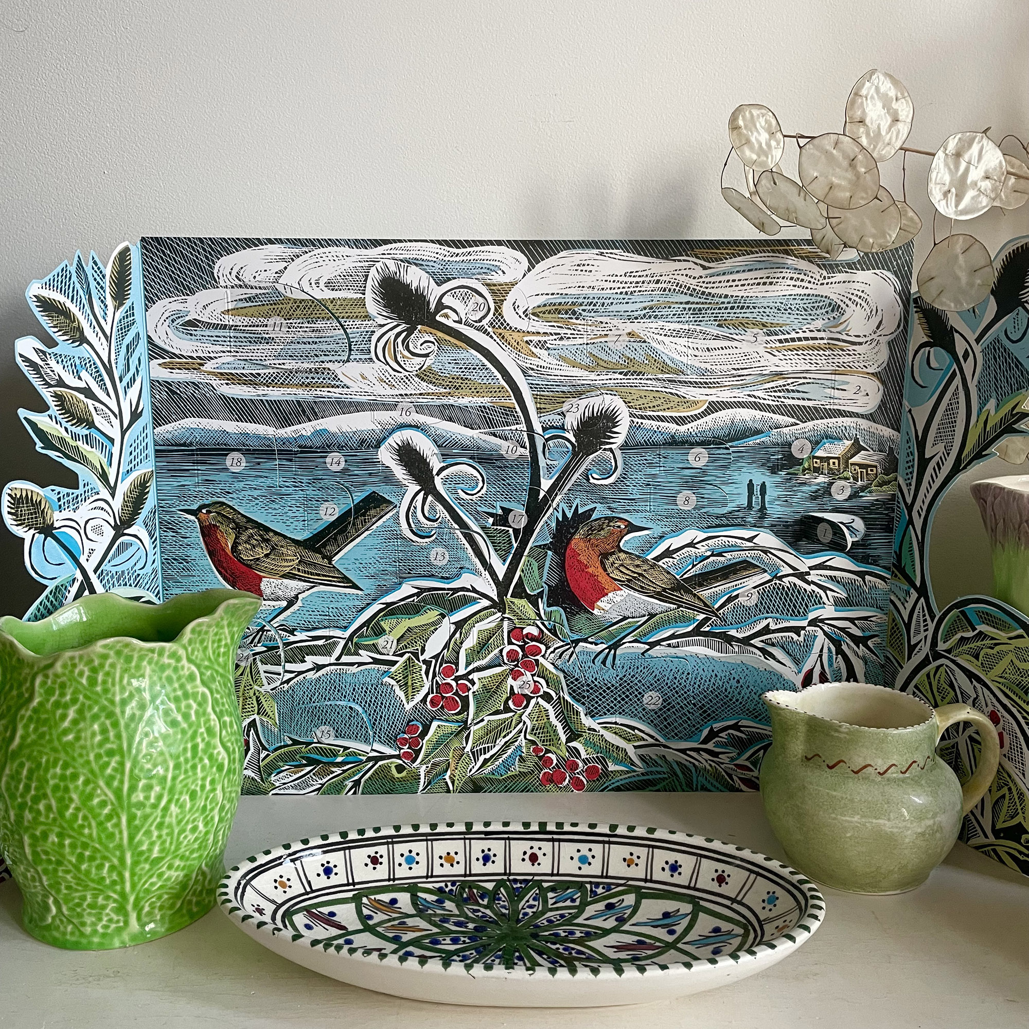 advent calendar on a shelf with some vintage pottery