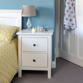 White bedside table in furnished bedroom
