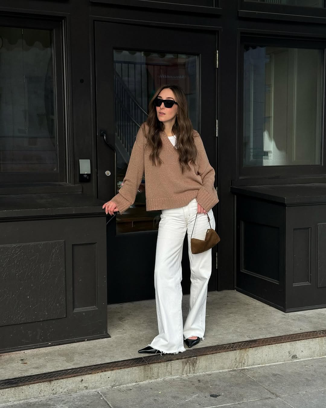 Influencer Sarah Rose Palm wearing a v-neck jumper, white jeans and pointed-toe heels.