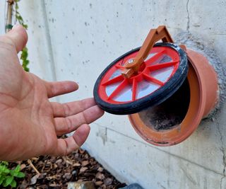 A drainage pipe at the base of a raised bed