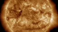 A yellowish brown view of the sun with lots of glowing activity.