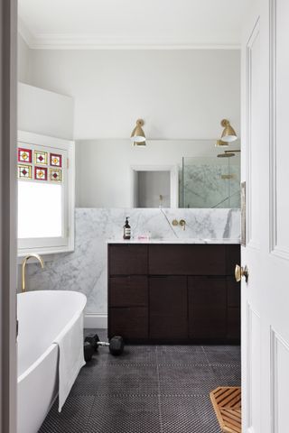 A bathroom with patterned dark tiles