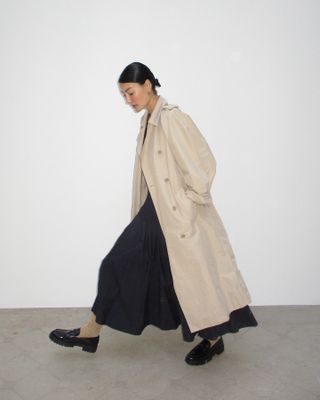 Woman wearing long skirt and trench coat.